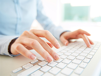 A woman typing on a keyboard